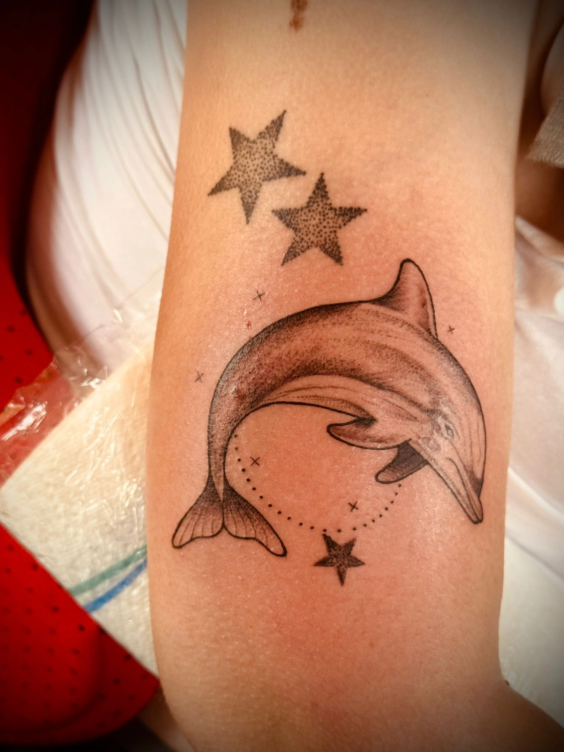 Kunstraum – Tätowierung – Schwarz-graue Tätowierung mit Fisch und Sternen auf dem Arm 