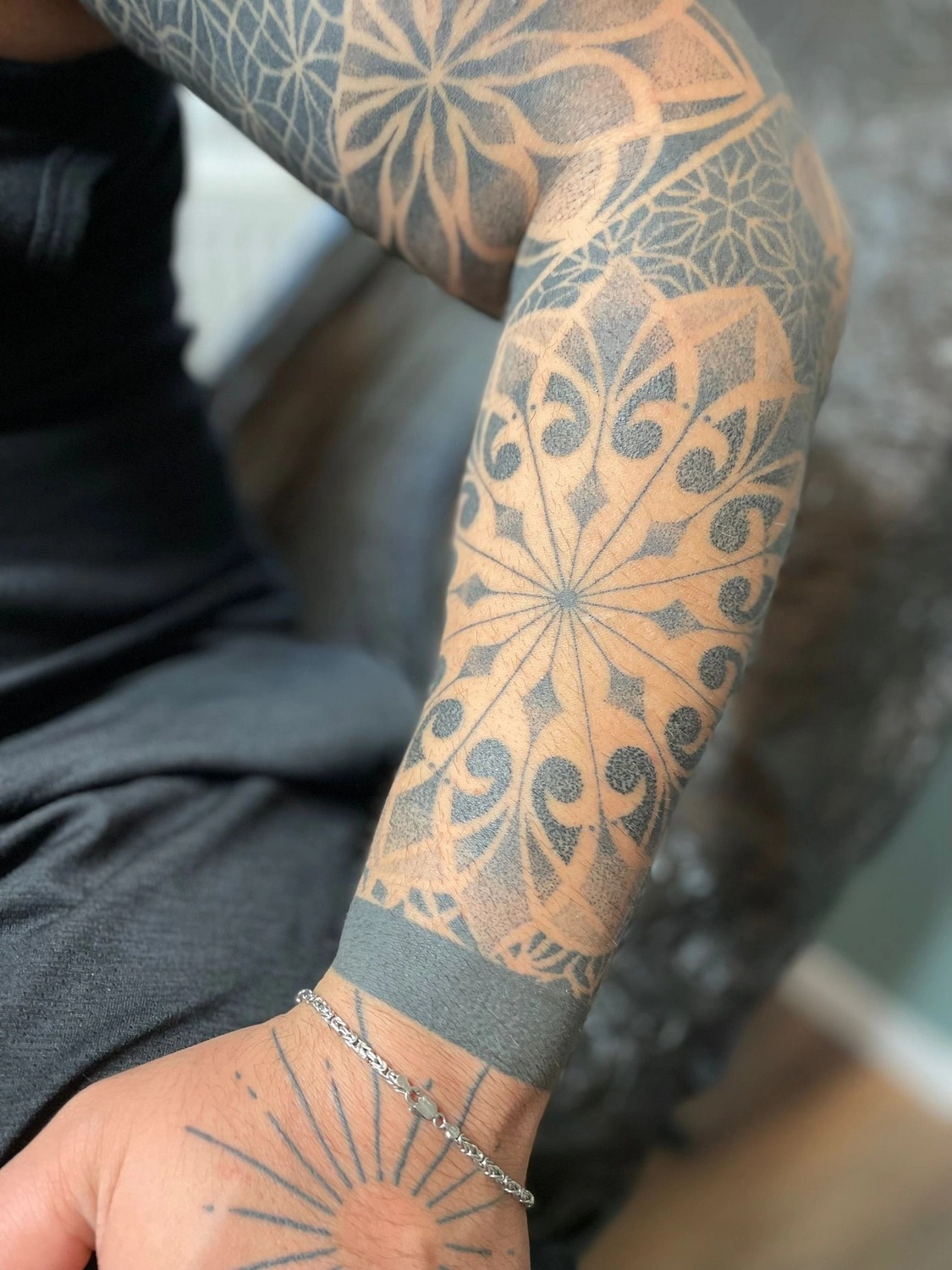 Kunstraum – Tätowierung – Schwarz-graue ornamentale Tätowierung auf dem Arm