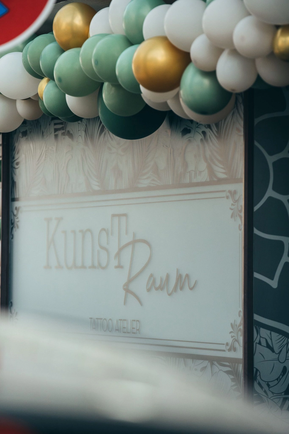 Kunstraum – Tattoo-Arbeiten – Kunstraum-Schild mit Luftballons verziert