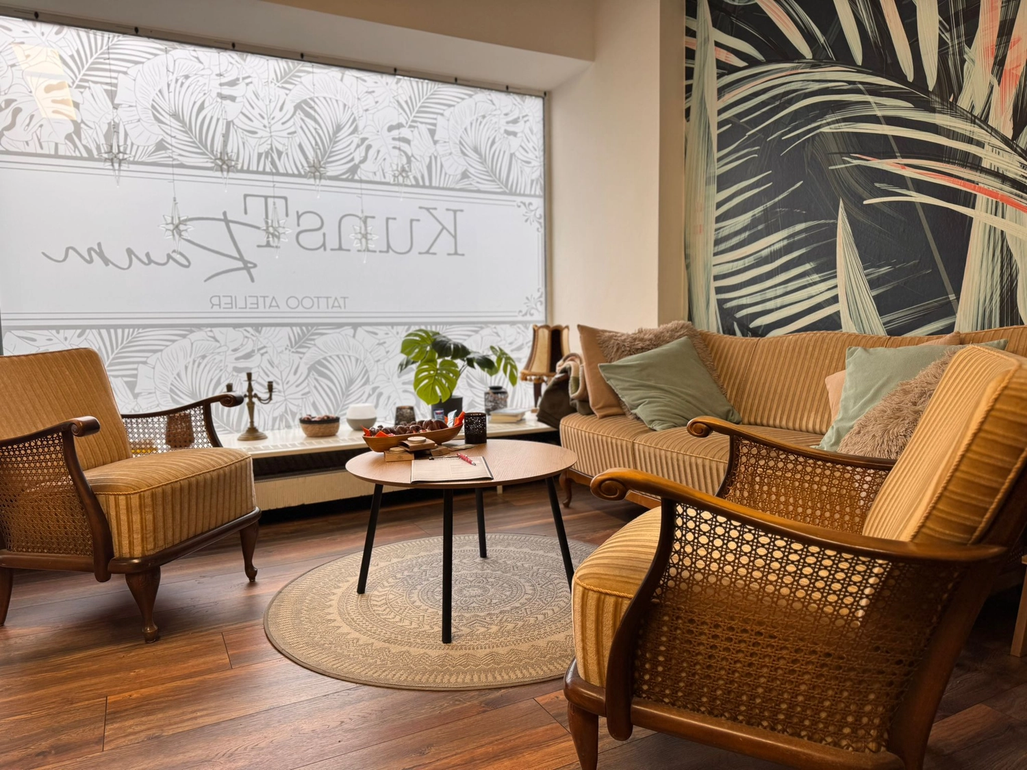 Kunstraum – Tätowierungsarbeiten – Raum mit Stühlen, Sofa und Couchtisch mit Dekorationsartikeln